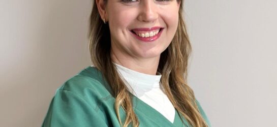 Auf dem Bild ist eine blonde Frau zu sehen mit weißem Oberteil. Ihr Name ist Maria und sie ist eine Mitarbeiterin von Dermacare Wien.