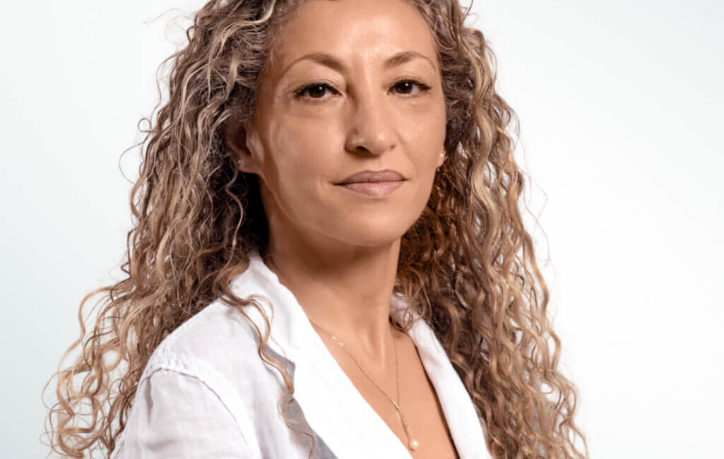 Auf dem Bild ist eine blonde lockige Frau zu sehen, die einen Arztkittel trägt. Ihr Name ist Dr. Seiser.