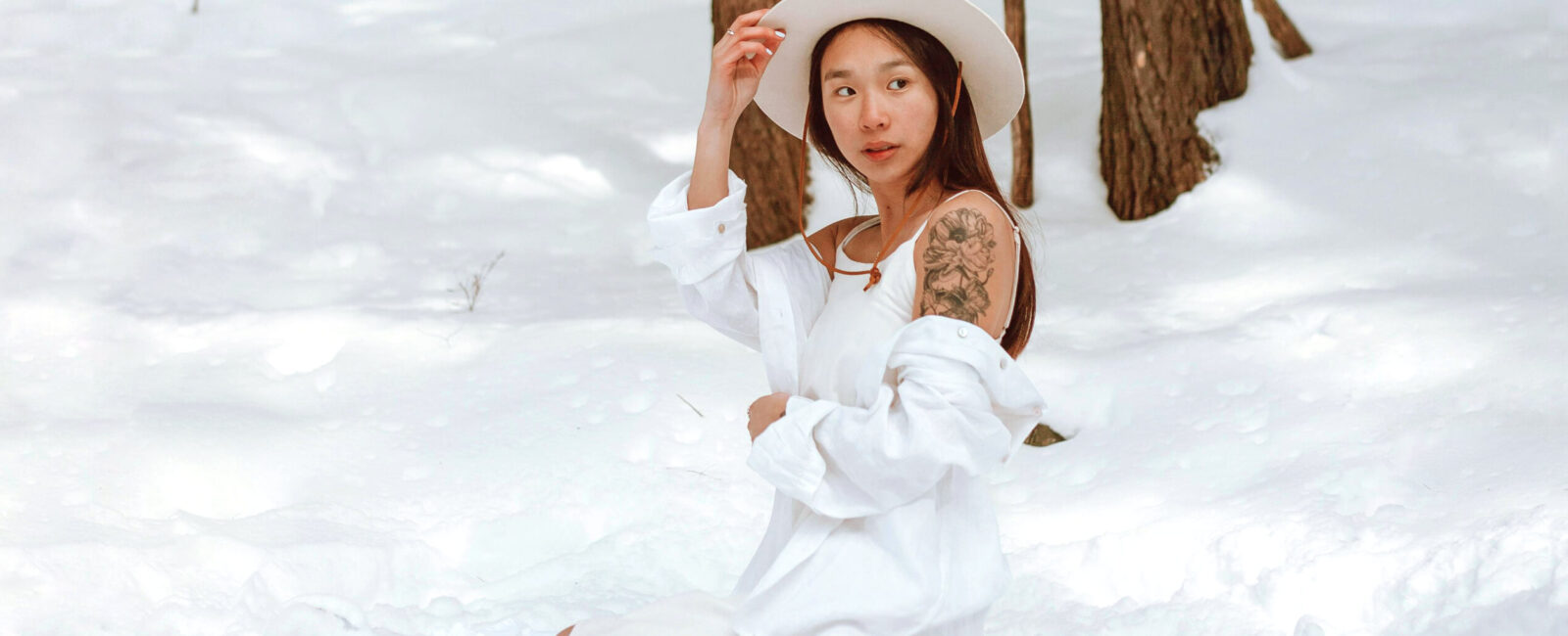 In diesem Bild sehen wir eine junge Frau, die sich in einer schneebedeckten Winterlandschaft befindet. Sie trägt ein langes, weißes Kleid und einen hellen Hut, was harmonisch mit der winterlichen Umgebung verschmilzt. Auf ihrem Arm ist ein großes, auffälliges Tattoo sichtbar, das durch den Kontrast zur hellen Kleidung und dem Schnee hervorgehoben wird. Diese Szene unterstreicht die Idee, dass der Winter die ideale Jahreszeit ist, um sich für eine Tattooentfernung zu entscheiden. Da die Haut in dieser Zeit weniger der Sonne ausgesetzt ist, wird das Tattoo-Lasern sicherer und effektiver. Für diejenigen, die nach einer professionellen Tattoo-Entfernung in Wien suchen, ist Dermacare eine erstklassige Wahl. Mit modernster Technologie und kompetenter Betreuung können unerwünschte Tätowierungen sicher und nahezu schmerzfrei entfernt werden. Die Tattoo lasern Kosten hängen von der Größe und Beschaffenheit des Tattoos ab, und individuelle Beratung ist der Schlüssel, um die besten Ergebnisse zu erzielen. Im Winter, wenn weniger direkte Sonneneinstrahlung die Haut beeinflusst, ist die ideale Zeit, um Tattoos zu weglasern und die Haut optimal zu schonen. Denken Sie darüber nach, Ihr Tattoo entfernen zu lassen? Kontaktieren Sie Dermacare in Wien und informieren Sie sich über die Möglichkeiten, Ihr Tattoo professionell und effektiv entfernen zu lassen.
