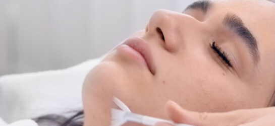 Aknenarben behandeln – Welche Methoden wirklich helfen Auf dem bild ist eine Frau sichtbar die sich ihre Aknenarben behandeln lässt. sie ist bei Dermacare Wien und bekommt ein Peeling.
