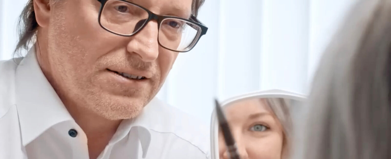 Was kostet Botox für die Stirn? Das Bild zeigt eine Beratung vor der Botox Behandlung. Ein Arzt klärt die Patientin über die Botox Kosten für Stirn auf.