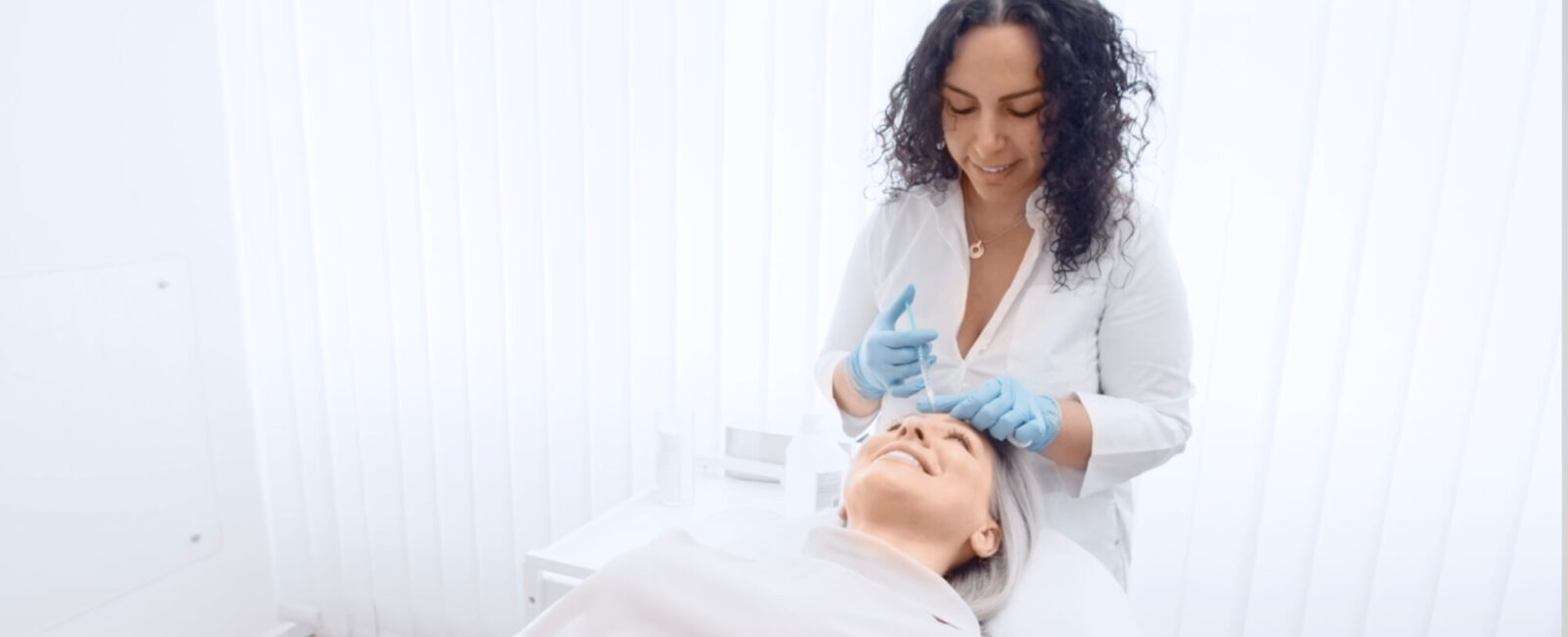 Auf dem Bild erkennt man eine Patientin die auf einer Liege liegt und gerade eine Botox Behandlung von Dermacares Ärzten erhaltet.