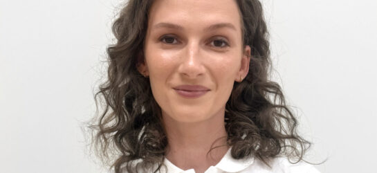 Dr. med. univ. Alica Píšteková Dr. Alica Pistekova ist Ärztin im Dermacare Insitut Wien. Sie hat braune, lockige Haare und lächelt im weißen Hemd in die Kamera.
