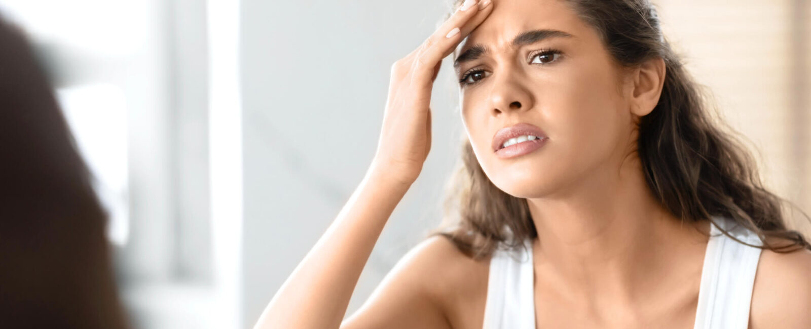 Auf dem Bild ist eine Frau zu sehen die eine Faltenunterspritzung mit Botox machen möchte um ihre Stirnfalten zu glätten.