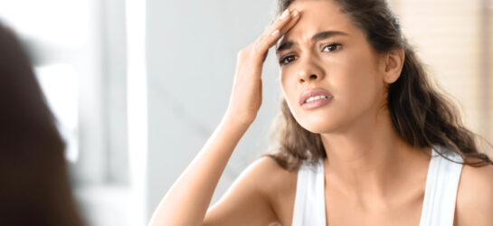 Auf dem Bild ist eine Frau zu sehen die eine Faltenunterspritzung mit Botox machen möchte um ihre Stirnfalten zu glätten.