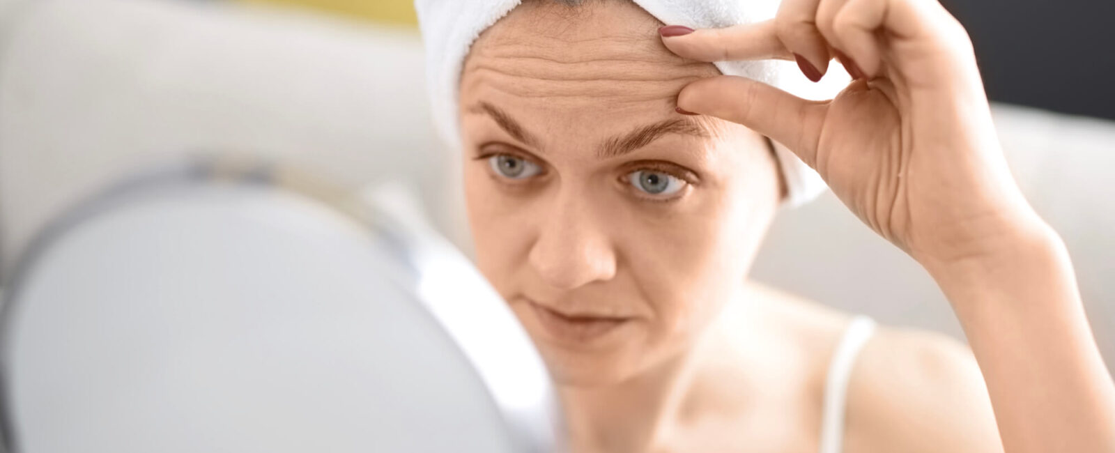 Botox im Gesicht: Die besten Zonen für Faltenunterspritzung mit Botox Die Frau auf dem Bild wundert sich gerade ob eine Faltenunterspritzung mit Botox ihre Stirnfalten glätten kann.