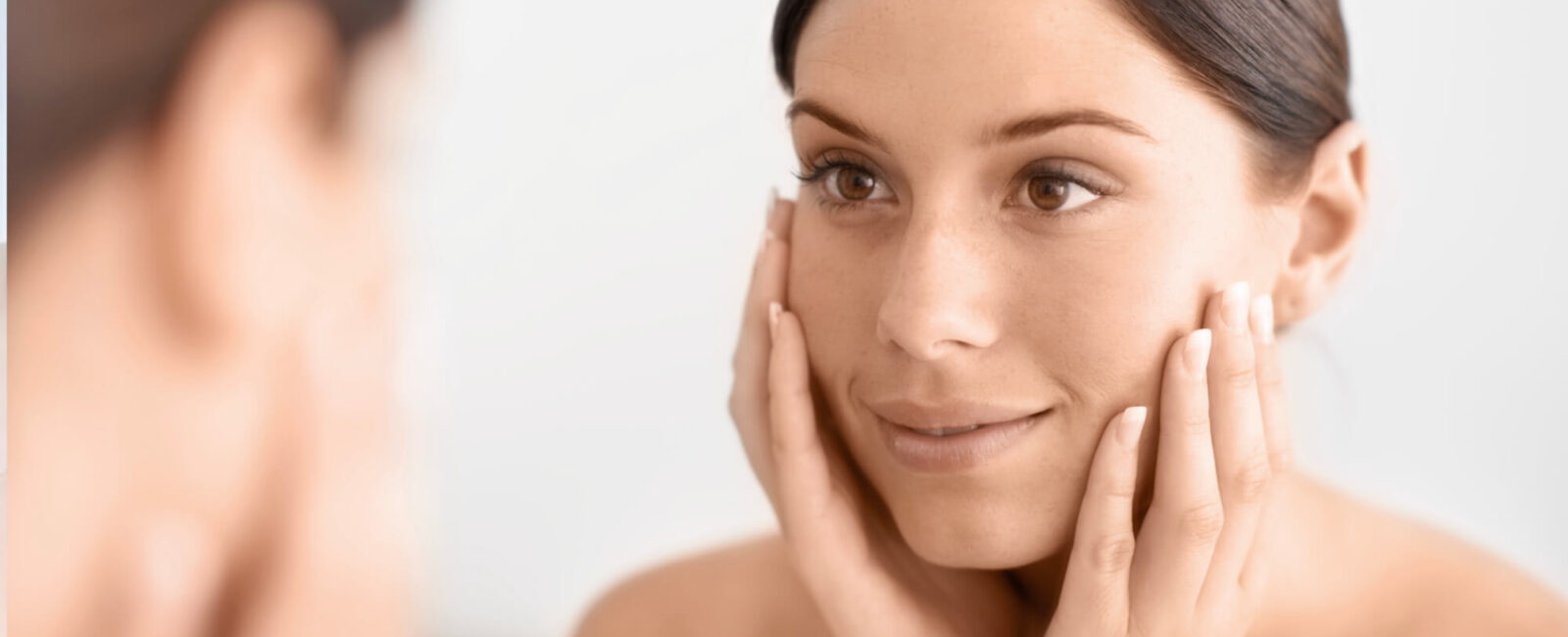 Hier sieht man eine Nahaufnahme vom Gesicht einer Frau. Sie ist froh über das REsultat der Gesichtsreinigung mit Wasser und fragt sich dank diesem Blogartikel nicht mehr was Aquafacial vs Hydrafacial bedeutet.