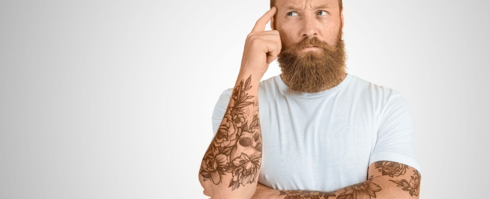 Das Bild zeigt einen Mann der sich sorgen um seine Tattoos im Job macht. Vielleicht kann er seine Jobchancen verbessern. Wir bei Dermacare stehen gerne zur Beratung bereit.