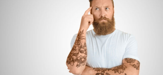 Jobchancen verbessern: Tattoos im Job Das Bild zeigt einen Mann der sich sorgen um seine Tattoos im Job macht. Vielleicht kann er seine Jobchancen verbessern. Wir bei Dermacare stehen gerne zur Beratung bereit.