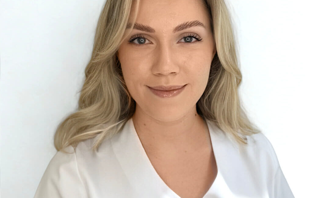 Auf dem Bild ist eine Blondine zu sehen. Ihr Name ist Alexandra und sie ist Empfangsmitarbeiterin bei Dermacare Donaustadt.