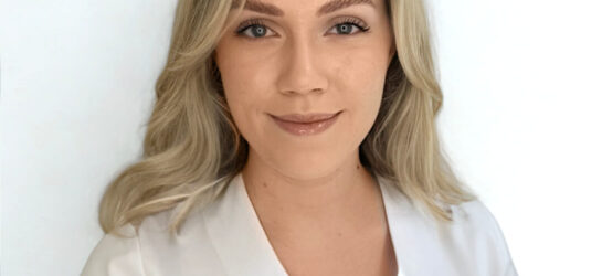 Auf dem Bild ist eine Blondine zu sehen. Ihr Name ist Alexandra und sie ist Empfangsmitarbeiterin bei Dermacare Donaustadt.