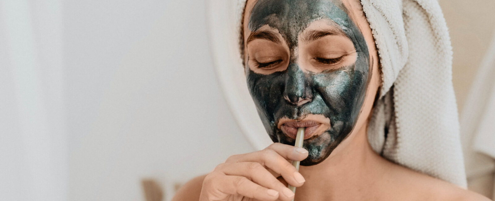 Auf diesem Bild sieht man eine Frau die gerade gegen ihre Pickel vor dem Date ankämpft. Sie trägt eine Gesichtsmaske.