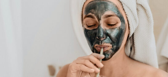 Auf diesem Bild sieht man eine Frau die gerade gegen ihre Pickel vor dem Date ankämpft. Sie trägt eine Gesichtsmaske.