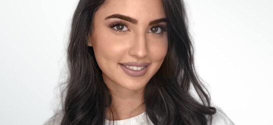 Auf dem Bild ist eine schwarzhaarige Frau zu sehen. Ihr Name ist Rivka und sie ist eine Mitarbeiterin von Dermacare Wien.