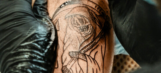 Hier auf diesem Bild sieht man eine Person die sein Tattoo loswerden möchte. Man sieht sein schlecht gestochen Tattoo auf der Schulter das den Sensenmann zeigt.